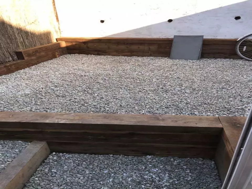 decorative aggregate stones laid in sleeper bordered area that includes steps and walling around the garden.