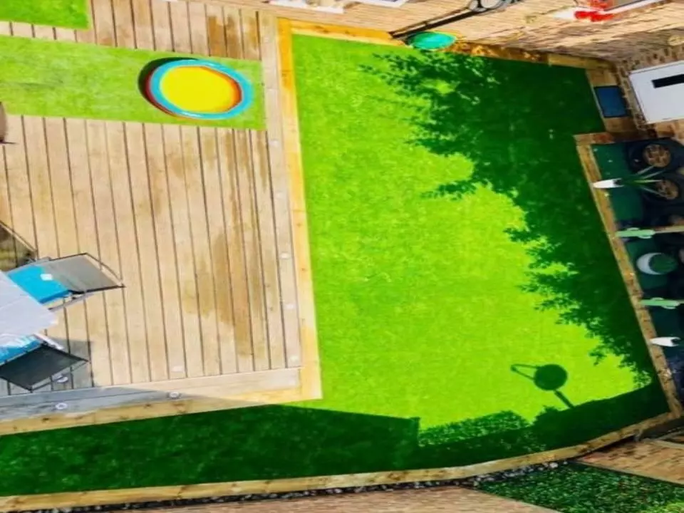 Large garden area with artificial lawn and bordered with sleepers and a small paddling pool