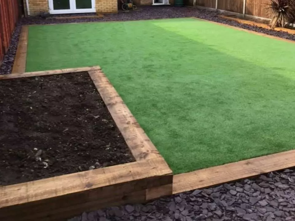 Large garden area with artificial lawn and bordered with sleepers and a small paddling pool