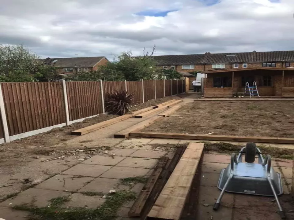 new closed panel board fencing along the left hand side of a large garden while work is being completed on the rest to install artificial grass and sleepers.